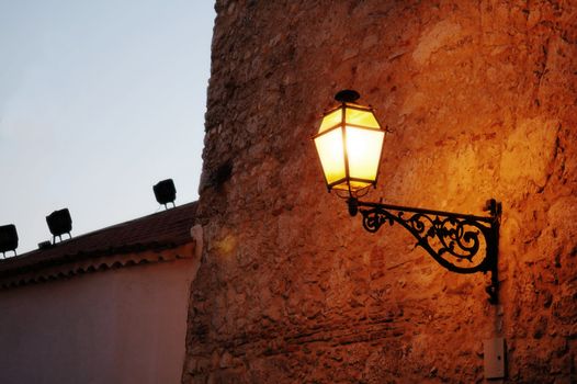 The antique lantern (street lamp) hanging on the (exterior) wall of residential house