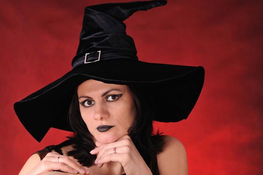 Young witch with a pumpkin on a red  background