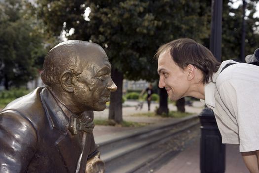 The young man looks in the face to a statue