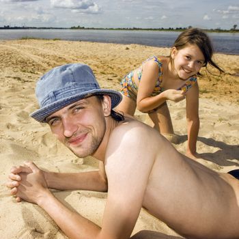 The young man and the girl on a beach at the river