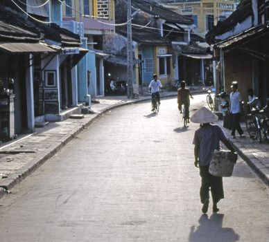 Old man returns from market in Street of old Hoi An.