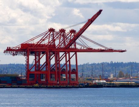 Port of Seattle Contaner Cranes v1 are opened up like giant jaws and set against a blue sky and the waters of Puget Sound.
