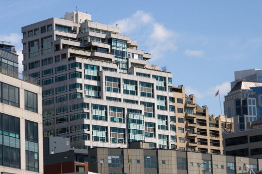 Urban Living v2 is a capture of terraced apartment and other buildings in the downtown area of Seattle Washington which is located at the shores of Puget Sound. It is set against a blue sky with white clouds. There are many windows and the building is shapped with stair like steps up to the heavens.
