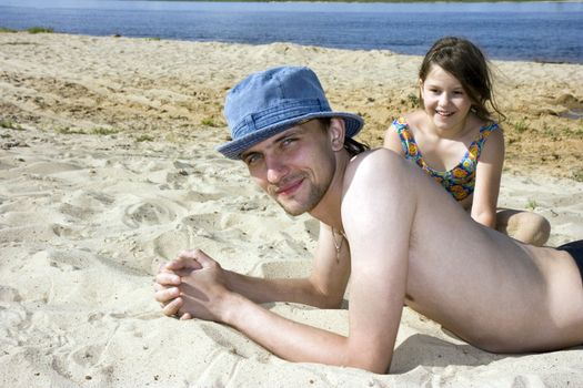 The young man and the girl on a beach at the river