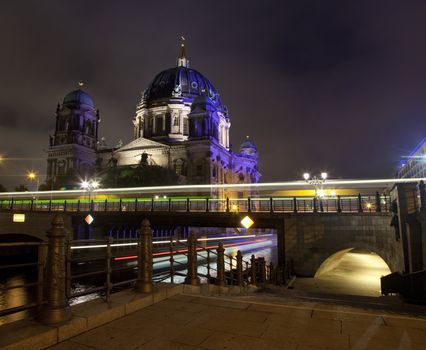 Light trails from a bus and a boat with the Berliner Dom in the background.  