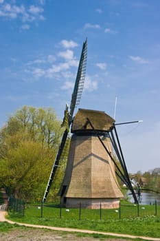 Dutch mill in city with residential houses in background on april afternoon