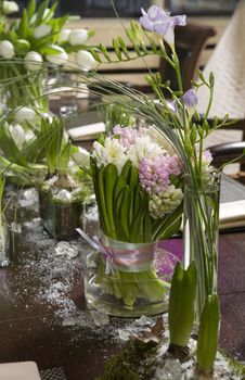  Bouquet of  tulip and hyacinth in vase of glass. Decoration of dining table. 