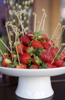 strawberries with stick in vase on table 