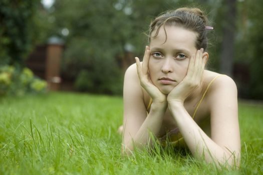 Young woman  lying on the grass  in summer park