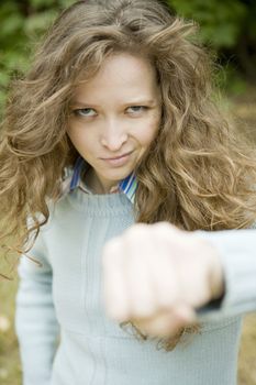 Portrait of an attractive young aggressive female punching