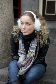 attractive girl sitting on on pavement in street in London.
