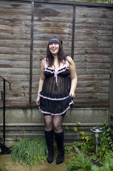 Attractive young laughing woman standing at fence