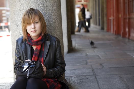 young attractive girl with red hair sitting on street, waiting. London. Covern Garden.