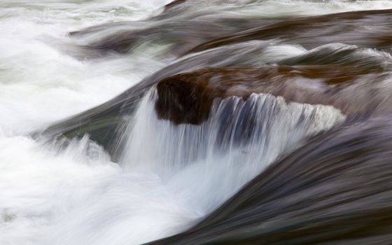 Long exposure shot of a raging river over rocks