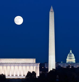 Full Harvest moon rising above the Lincoln Memorial with Washington Monument and Capitol building aligned