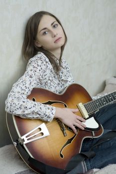 Attractive young girl playing guitar. Cowgirl