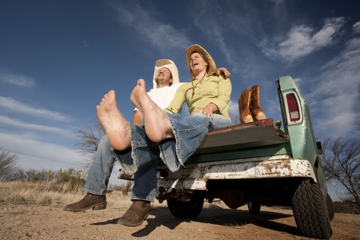 Portrait of Cowboy and woman on pickup truck bed