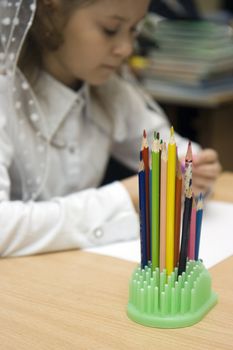 Photo of colour pencils standing on a school desk