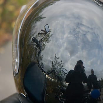 Reflexion of the sky with clouds in a motorcycle helmet