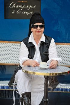 Young woman sitting in street cafe. Paris