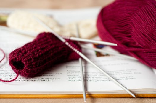 Knitted children sock with book and wool.