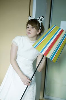 portrait of young cute thoughtful girl wearing white dress with dog`s ears