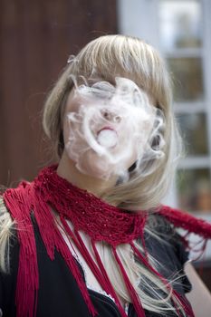 Blond woman breathe out smoke