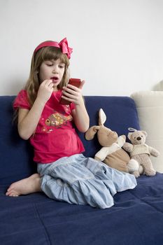 little cute girl doing make up looking in mirror. 