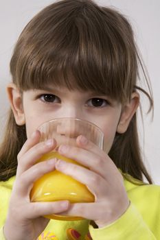little cute smiling girl seven years old drink orange juice