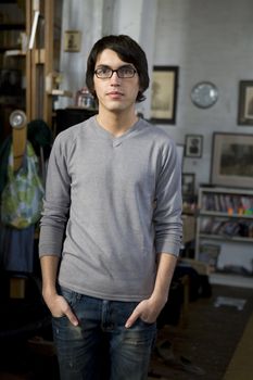 portrait young handsome man in glasses standing in the middle of the room