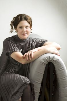 Portrait of young adorable smiling woman sitting on sofa