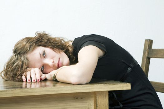 upset girl put her head down table. Woman`s problem.