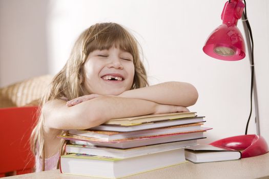 Little cute laughing  girl put head on books