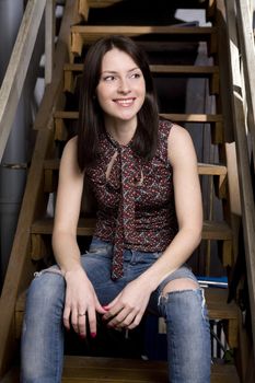 Young attractive smiling woman sitting on stairs