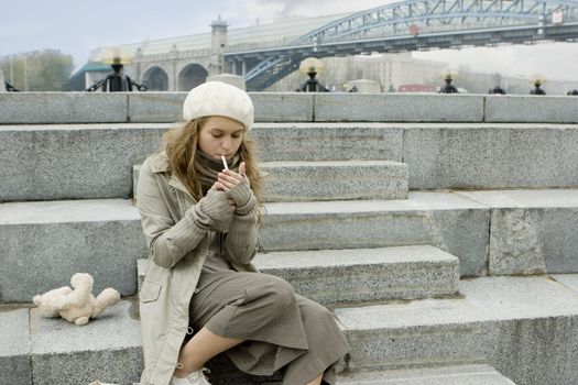 young teen girl sitting on the jaggies and smoking
