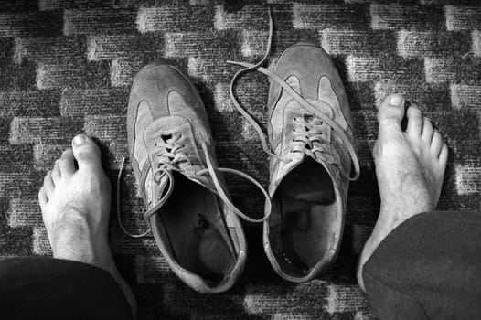 black and white photo; tired feed, old shoes