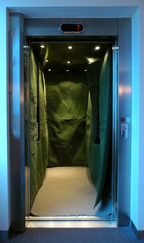 open steel elevator covered with green sheet