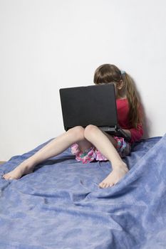 Cute little girl playing with laptop