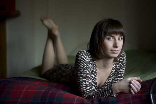 portrait young attractive brunette woman lying on bed