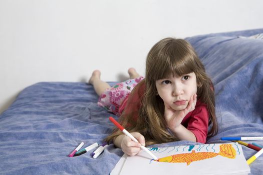 little cute serious girl seven years old with drawing picture