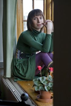 Attractive woman sitting on window-sill