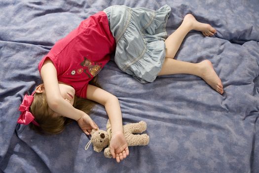 little sleaping girl in bow witn teddy-bear