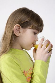 little cute girl seven years old drink orange juice