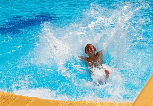 Young boy falls into the water with a waterslide