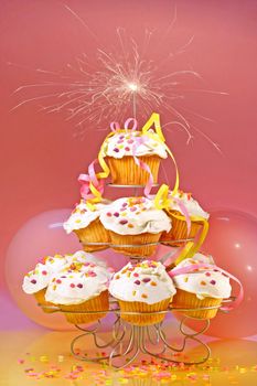 Cupcakes with sparkler on top against pink background