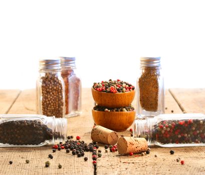 Spice glass containers on old wood table with white background