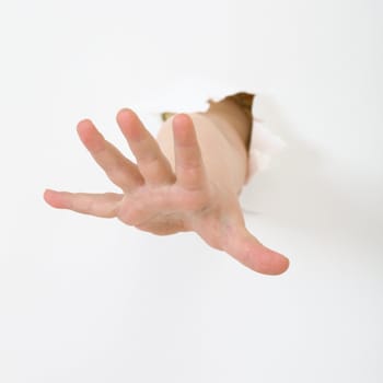 Child's hand stick out from hole in sheet of paper