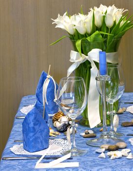 Table decorated with tulips bouquet and candles