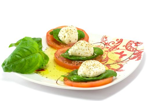 Caprese salad close-up with olive oil green basil and  pepper 