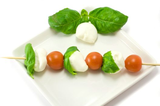 Caprese salad close-up with olive oil green basil and  pepper 